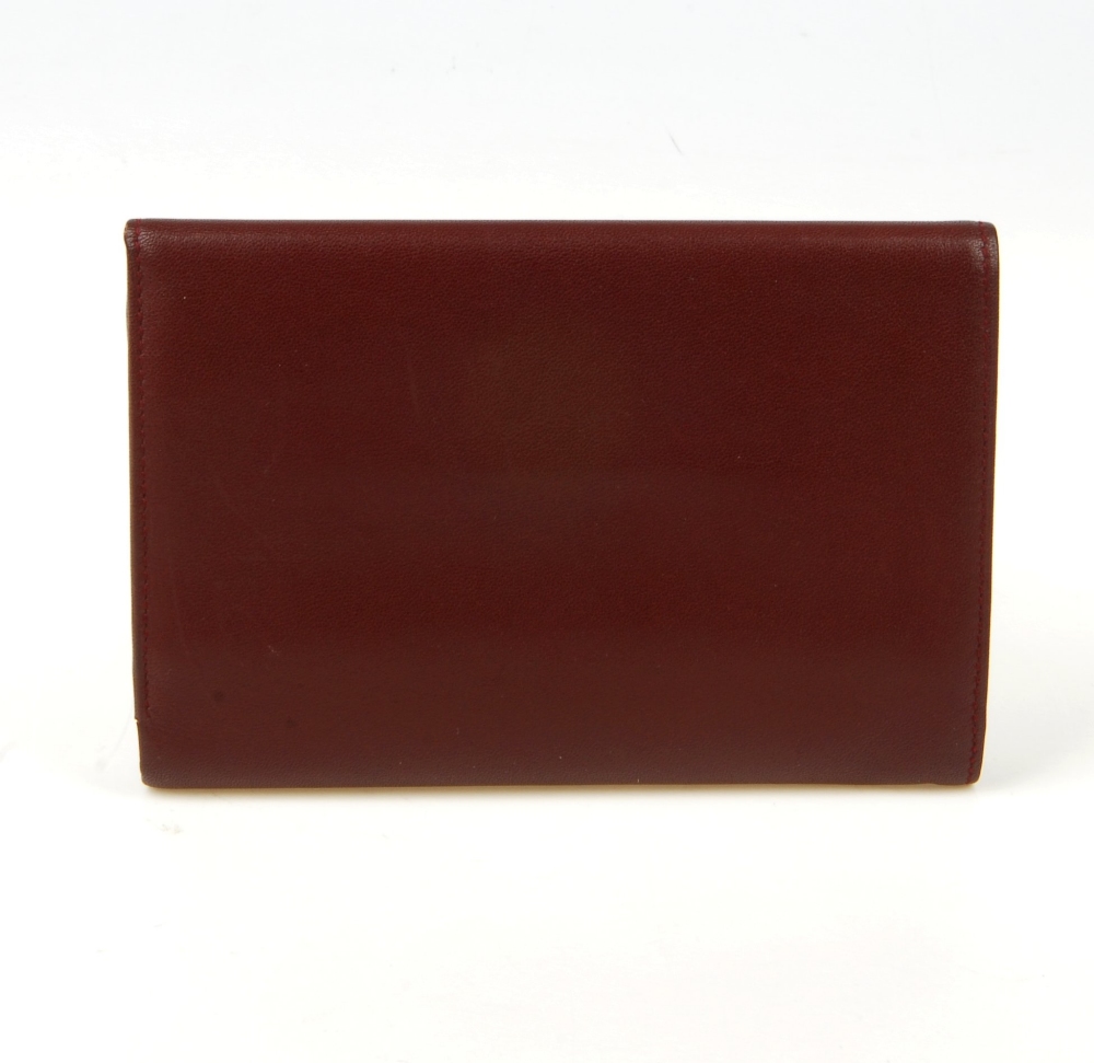 CARTIER - a Bordeaux leather purse. Designed with gold-tone corner guards and maker's embossed - Image 6 of 12