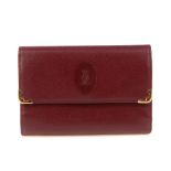 CARTIER - a Bordeaux leather purse. Designed with gold-tone corner guards and maker's embossed