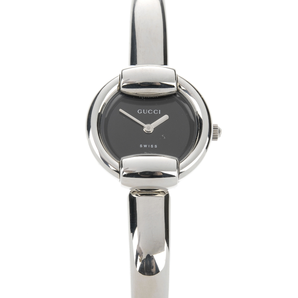 GUCCI - a stainless steel quartz lady's 1400L bangle watch. The plain black dial, with a round case,