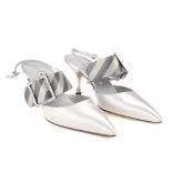 MANOLO BLAHNIK - a pair of slingback kitten heels. Featuring a matte silver satin exterior with an