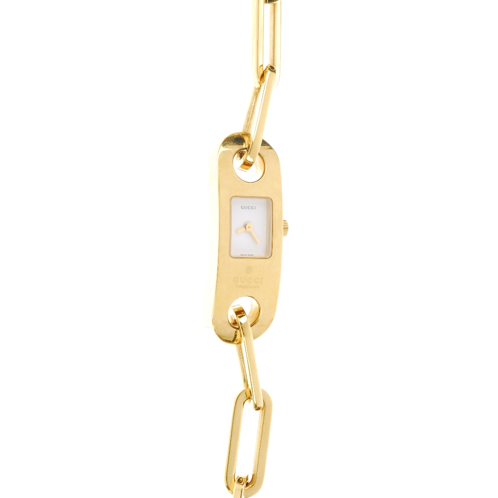 GUCCI - a lady's 6100L bracelet watch. The white dial, with a gold plated case fitted to a gold