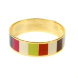 COACH - a Legacy striped bangle. The gold-tone bangle featuring multicoloured striped enamel inlay
