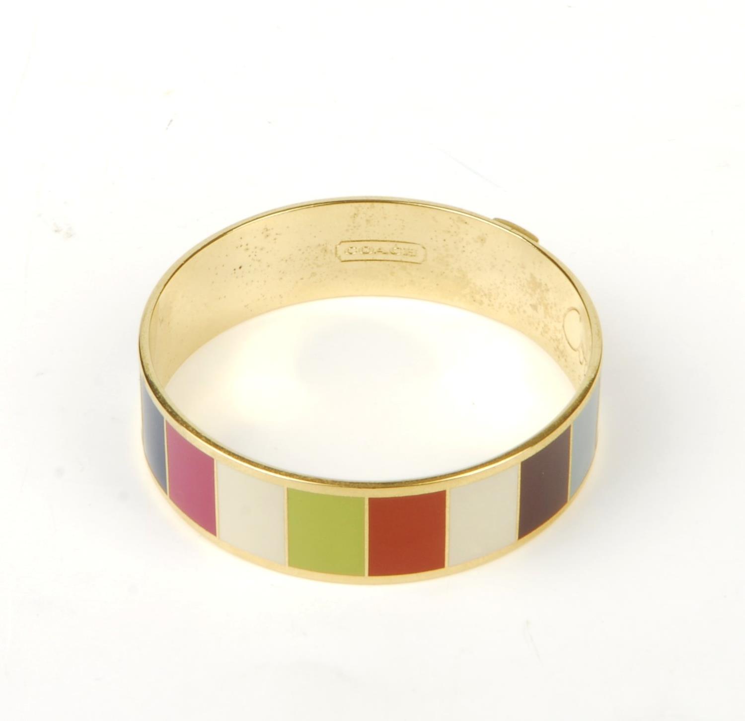 COACH - a Legacy striped bangle. The gold-tone bangle featuring multicoloured striped enamel inlay - Image 2 of 9