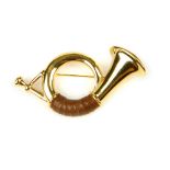 BURBERRY - a brooch. Designed as a gold-tone French horn with leather detail. Signed Burberrys.