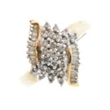 A 9ct gold diamond dress ring. The single-cut diamond stepped cluster, with baguette-cut diamond