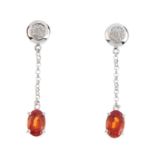 A pair of 9ct gold garnet and diamond earrings. Each designed as an oval-shape spessartine garnet,