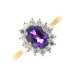 An 18ct gold amethyst and diamond cluster ring. The oval-shape amethyst, with brilliant-cut