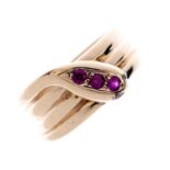 A 9ct gold synthetic ruby snake ring. Designed as a coiled snake, with circular-shape synthetic ruby