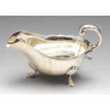 An Edwardian silver sauce boat, of typical form with high arch scroll capped handle, the whole