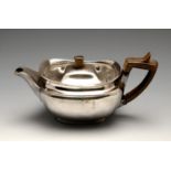 A George III silver bachelor teapot, the plain squat form with short spout and oblong footed base,