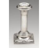 An early twentieth century silver mounted candlestick, the cylindrical column raised upon a square