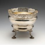 An Edwardian silver fruit bowl of circular form, the scrolled rim above a continuous pierced