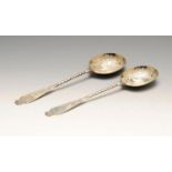 A pair of late Victorian silver fruit serving spoons, each silver-gilt bowl with bright-cut