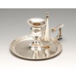 A Victorian silver chamberstick, the circular base with bead and husk borders enclosing a plain