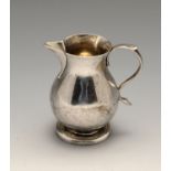 A George II silver sparrow beak cream jug, the typical baluster form to a footed base, crest