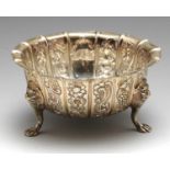 An early twentieth century Irish silver sugar bowl, the circular panel-sided form embossed with