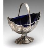 A Victorian silver pedestal sugar basket with swing handle, the panel-sided oval from with wavy edge