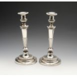 A pair of George III silver candlesticks, each with a circular stepped filled base with beaded