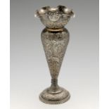 A white metal vase of Indian style, the circular stepped base with beaded edge and foliate