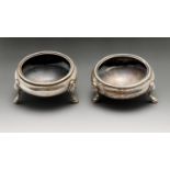 A late Victorian pair of silver open salts, each of plain circular form, raised upon three stepped