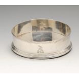 A George IV silver mounted coaster, the plain circular form with reeded rim above a crest