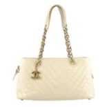 CHANEL - a cream chevron quilted iridescent leather Surpique handbag. Designed with a chevron