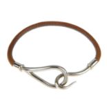 HERMÈS - a leather cord bracelet. The brown leather cord, with hook to one terminal and loop to
