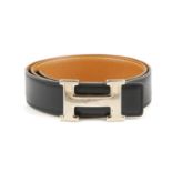 HERMÈS - a reversible logo buckle belt. Designed with smooth black leather to one side and grained