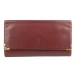 CARTIER - an envelope clutch. Crafted from maker's signature burgundy leather, with front logo