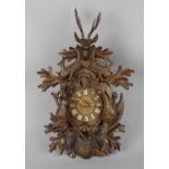 A 19th century Black Forest cuckoo clock, the heavily carved case detailed with stag head trophy,