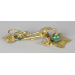 A gilt metal letter clip, the stylised scroll body modelled with floral engraved acanthus leaves,