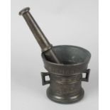 A bronze mortar and pestle, the mortar of typical flared cylindrical form with twin handles,