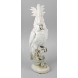 A Royal Dux porcelain figurine modelled as a cockatoo seated upon a branch, with marks to base,