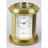 A Matthew Norman brass-cased oval carriage clock. The white Roman dial with Breguet hands, the