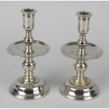 Two pairs of base metal (alloy) candlesticks, the first examples with circular drip trays above