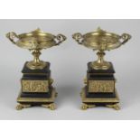 A pair of 19th century Regency style bronze urns, the shallow saucer shaped bowls with twin lion