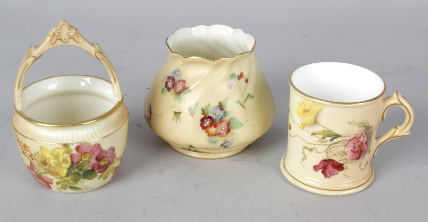 A group of Royal Worcester blush ivory porcelain items. Comprising: a miniature basket, two circular