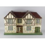 A large mid 20th century Triang wooden dolls house, with front opening double doors enclosing four