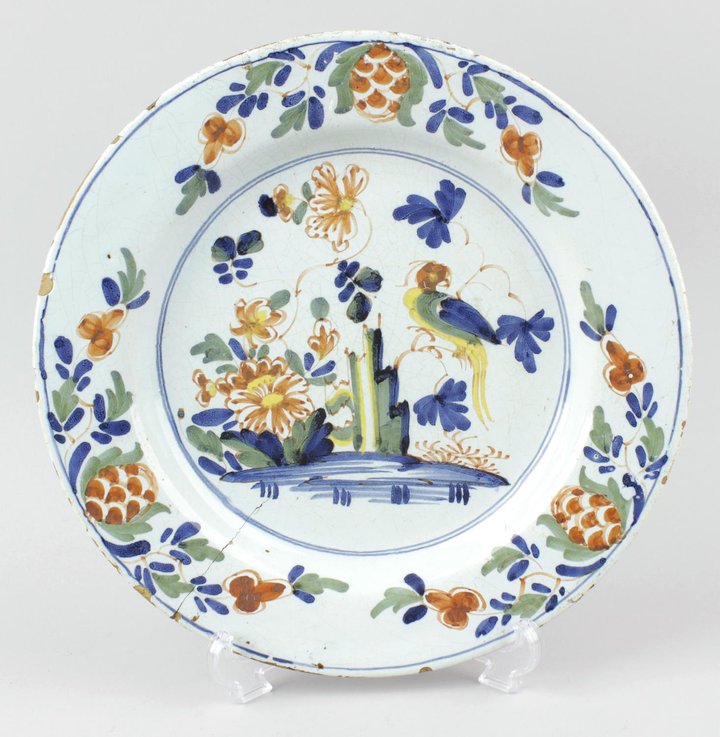A mid 18th century English polychrome delftware plate. Probably London or Bristol, the circular