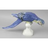 A Royal Dux porcelain figurine modelled as a parrot seated upon a branch, with marks to base, 8.5 (