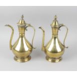 A pair of brass Middle Eastern ewers, the bulbous body with tapering neck, leading to hinged cover