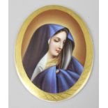 A Berlin porcelain plaque, probably KPM, of oval form depicting the Madonna, in painted gilt border,