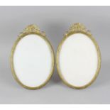 A pair of Neo Classical style cast gilt brass and bronze oval picture frames, with stylised ribbon