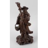 An Oriental carved rootwood figure of an elder. Circa 1900, the bearded male modelled wearing a