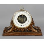 A Victorian brass bodied circular wall hanging aneroid barometer, the white black printed dial