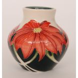 A small Moorcroft Pottery vase decorated with red poinsettia type flowers against a cream ground,