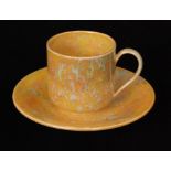 A Ruskin Pottery lustre coffee can and saucer decorated in a streaked and mottled yellow,