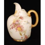 A Royal Worcester flatback jug decorated with gilt and enamel flowers against a blush ivory ground,