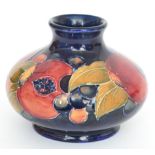 William Moorcroft - A small vase of footed compressed ovoid form with a flared collar neck,