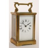 A late 19th Century French brass carriage clock with white enamelled dial and together with key,